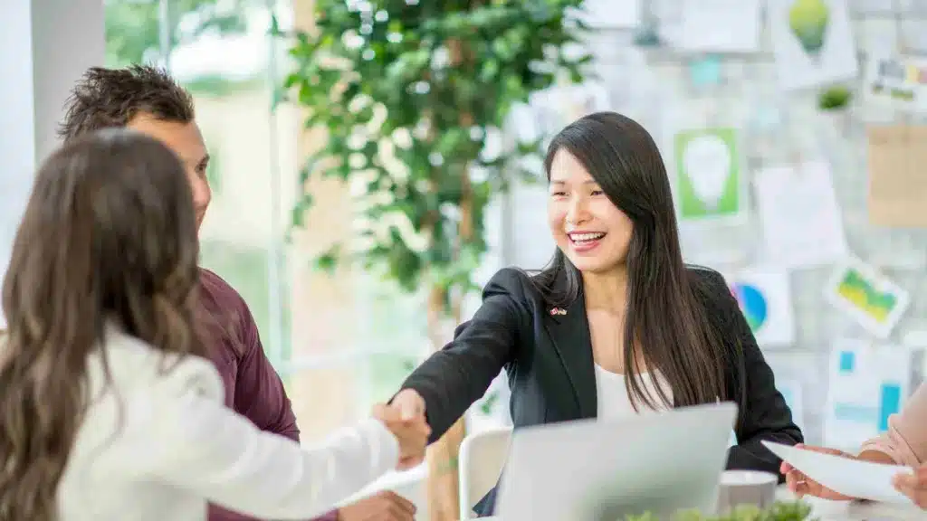 Successful coopetition business meeting with people shaking hands across board room table