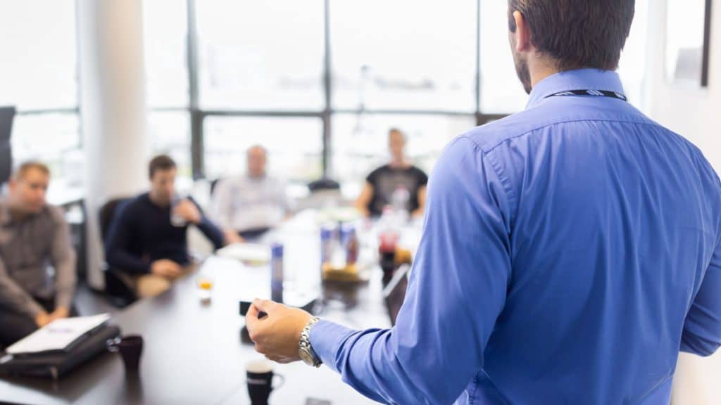 Person facilitating a brainstorming session in a meeting room