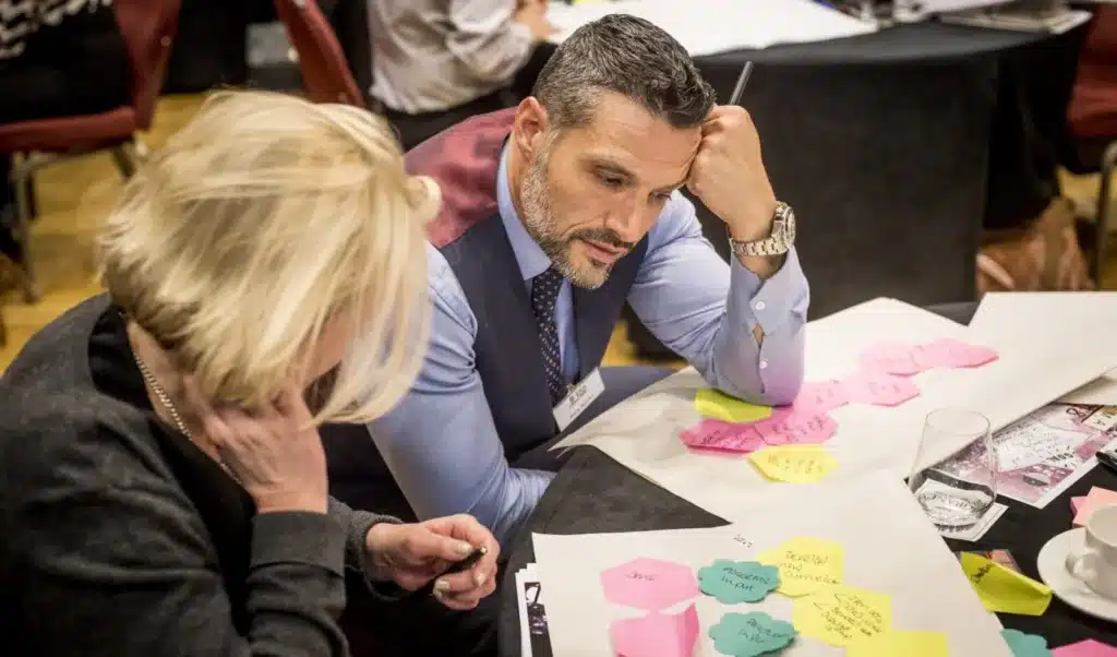 2 people looking at post-its