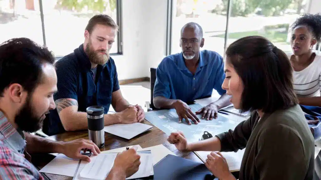 Stakeholders and business in a meeting room, discussing a project