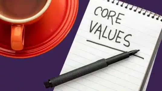 Cup of coffee alongside a notepad, with the words 'core values' written on it