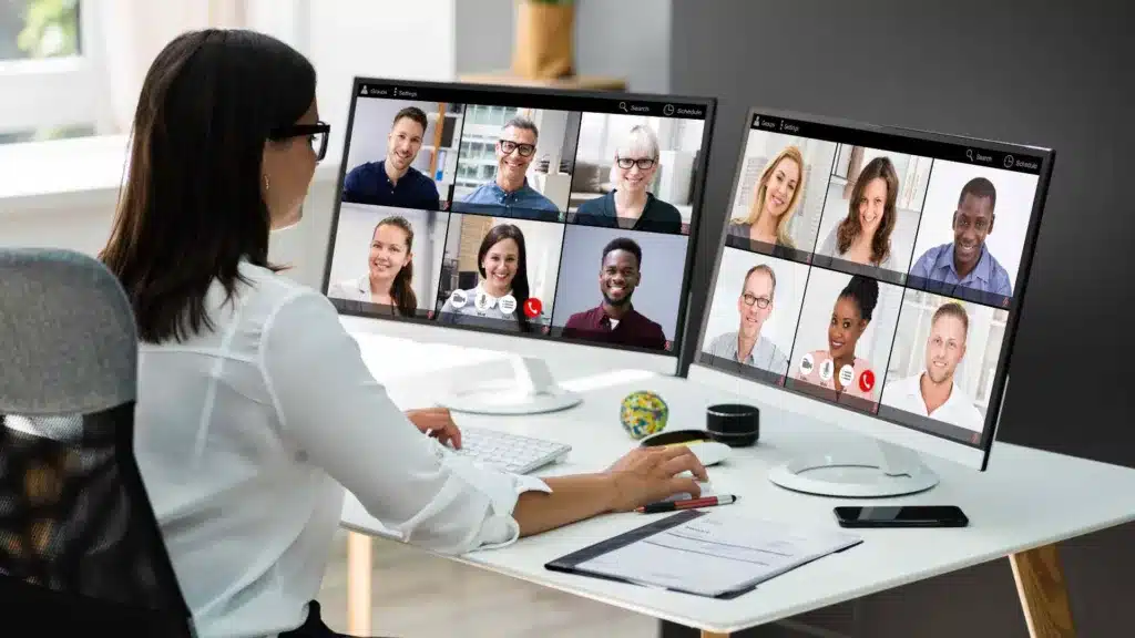 Facilitator in front of a computer, working to moderate a meeting online